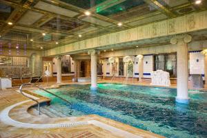 a large swimming pool in a building with columns at Hotel Spa Convento I in Coreses