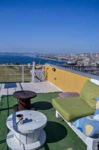 um pátio com um sofá e uma mesa no telhado em Lemuria Hostel em Valparaíso