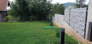 a fence in a yard next to a field at Mihaylova kushta in Lyubosh