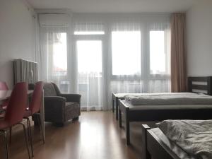 a room with three beds and a chair and a couch at Szelestey utcai apartman (Szombathely) in Szombathely