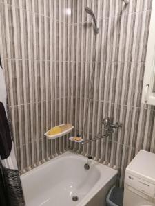 une petite salle de bain avec une baignoire et un lavabo dans l'établissement Tėjos guest house, à Šiauliai
