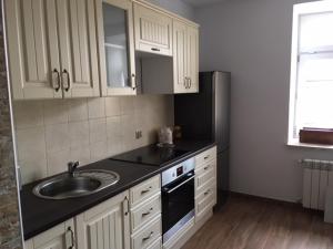 a kitchen with a sink and a refrigerator at Nowy Apartament CENTRUM - faktura VAT in Włodawa +5 photos