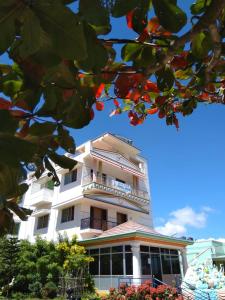 ein weißes Gebäude mit Balkon darüber in der Unterkunft Aruvi Hotel in Yelagiri