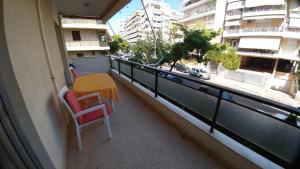 a balcony with a table and chairs and a view of a city at Proteus Apartment in Athens