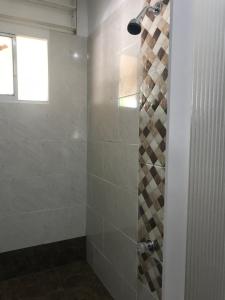 a bathroom with a shower with a glass door at Santa Marta Apartamentos Salazar - Maria Paula in Santa Marta