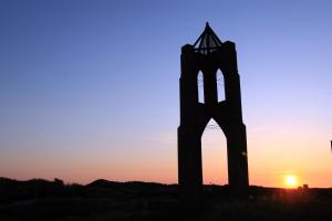 ボルクムにあるBORKUMUNTERKUNFT - WOH5 - IM HERZEN DER INSELの夕日を背景に見える塔のシルエット