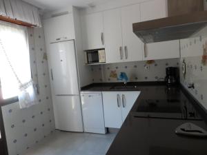 La cuisine est équipée de placards blancs et d'un réfrigérateur blanc. dans l'établissement Casa Con Encanto En Arnedillo, à Arnedillo