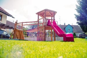 een speeltuin met een glijbaan in een tuin bij Gasthaus und Pension Zur Linde in Rot an der Rot