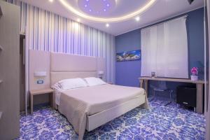 a bedroom with a white bed and a table and a window at Palazzo Aranci in Sorrento
