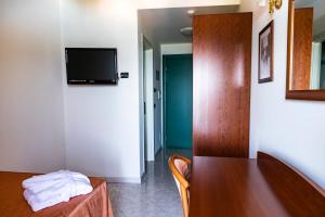 a dining room with a table and a tv on a wall at Hotel Za Maria in Santo Stefano di Camastra