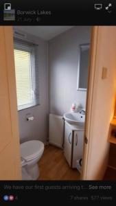 a bathroom with a white toilet and a sink at Carmels Caravan Borwick Lakes in Carnforth +15 photos