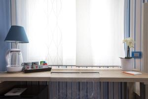 una scrivania in legno con lampada e lampada di B&B Degli Aranci a Sorrento