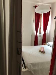 een slaapkamer met een bed en rode gordijnen bij 21House - Appartamento 1 in Busto Arsizio