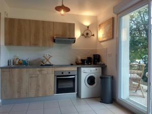a kitchen with a washing machine and a washer at Chic apart terrace garden parking in Cergy