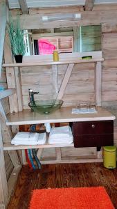 ein Badezimmer mit einem Waschbecken an einer Holzwand in der Unterkunft Le Bougainvillier Blanc in Pointe-Noire