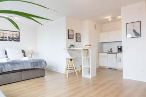 a white bedroom with a bed and a kitchen at Business Apartment mit Blick auf die Skyline von Essen in Essen