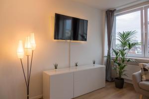 a living room with a white cabinet and a tv on the wall at Business Apartment mit Blick auf die Skyline von Essen in Essen