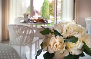 a bouquet of white roses in a vase on a table at Garda Room in Peschiera del Garda
