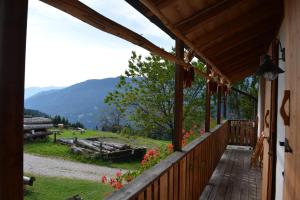 a porch of a cabin with a view of the mountains at Agritur Dalaip dei Pape in Fiera di Primiero