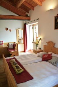 a bedroom with two beds and a window at Agritur Dalaip dei Pape in Fiera di Primiero