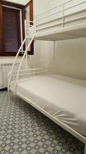 a white bunk bed in a room with a tile floor at Casa al mare con ampio giardino in Vasto