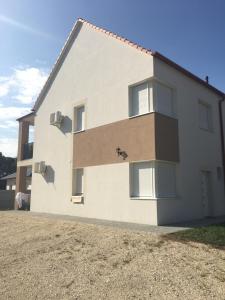 un edificio blanco con ventanas laterales en Szofi Apartman Pápa Fenyves u. 19., en Pápa