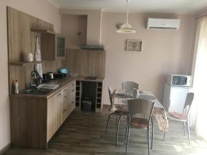 a kitchen with a table and chairs and a kitchen with a sink at Szofi Apartman Pápa Fenyves u. 19. in Pápa