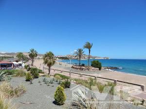 una playa de arena con palmeras y el océano en Casa Tosta, en San Juan de los Terreros