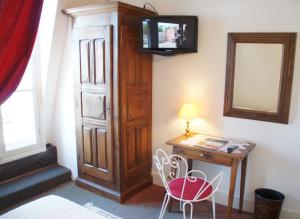 
a small room with a television and a chair at Hotel Montsegur in Carcassonne
