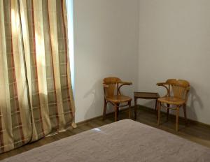 ワルシャワにあるPulawska Nr 1のベッドルーム1室(椅子2脚、ベッド1台、窓付)