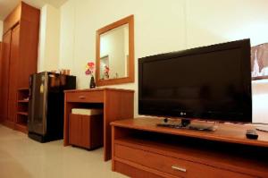 a living room with a flat screen tv on a dresser at Rafael Hotel and Mansion Bangkok - SHA Extra Plus Certified in Lat Krabang