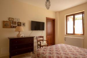 a bedroom with a bed and a dresser and a television at Ulivo Centenario in Selva di Fasano