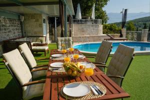 a wooden table with a bowl of fruit on it next to a pool at Holiday Home Gustirna in Selca
