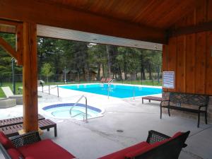 a pavilion with a swimming pool with benches at Fairmont Mountain Bungalows in Fairmont Hot Springs