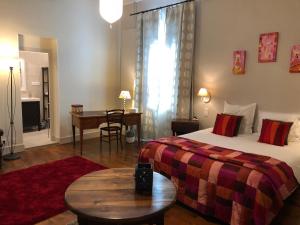 a hotel room with a bed and a table and a desk at Gentil'Home - Toulouse B&B Prestige in Fenouillet