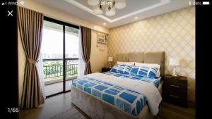 a bedroom with a bed and a large window at Grand Apartment near BGC in Manila