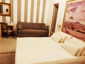 ナポリにあるLa Bella Napoli B&Bのベッドルーム(大型ベッド1台、ソファ付)