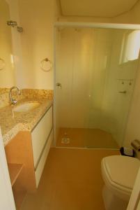 y baño con aseo, lavabo y ducha. en Edificio Villa Milano en Bombinhas