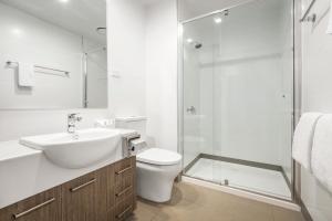 a bathroom with a toilet and a sink and a shower at Quest Nowra in Nowra