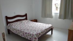 1 dormitorio con 1 cama con manta de flores en Casa em Mariscal - 5 a 8 pessoas, en Bombinhas