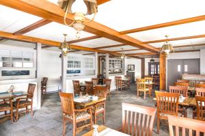 restauracja z drewnianymi stołami i drewnianymi krzesłami w obiekcie Mount Peyton Resort & Conference Centre w mieście Grand Falls-Windsor