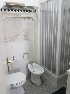 a white bathroom with a toilet and a sink at Comfort City Hub - Metro Lisbon in Amadora
