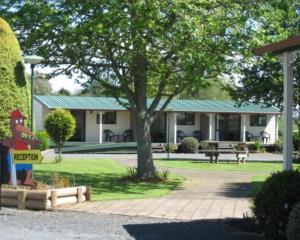 una casa con un cartel de pollo delante de ella en Otorohanga Kiwi Holiday Park en Otorohanga