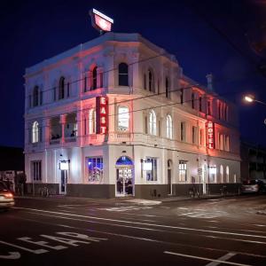 un edificio con luces rojas en el lateral. en East Brunswick Hotel, en Melbourne