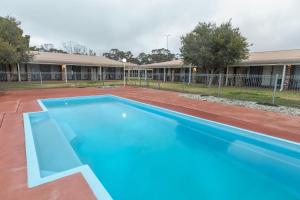 een groot blauw zwembad voor een gebouw bij Club Inn Motel in West Wyalong