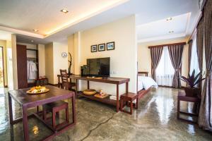 Retreat Siargao Resort في جنرال لونا: غرفة فندقية بسرير وطاولة وكراسي