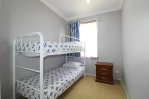 a bedroom with two bunk beds and a window at Beachfront 6, 25 Willow Street in Crescent Head