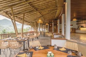 
a dining room with tables and chairs and a patio at Wapa di Ume Sidemen - CHSE Certified in Sidemen
