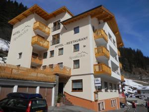 un edificio con balconi e una macchina parcheggiata di fronte di Hotel Alpenfrieden a Kappl