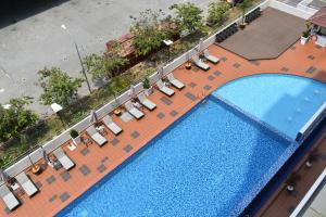 - une vue sur la piscine et ses chaises longues dans l'établissement Tenera Hotel, à Bangi